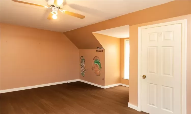 Bonus room featuring dark wood-type flooring, ceiling fan, and vaulted ceiling