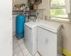 Laundry room featuring washing machine and clothes dryer and light tile patterned floors