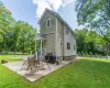 Rear view of property with a lawn and a patio