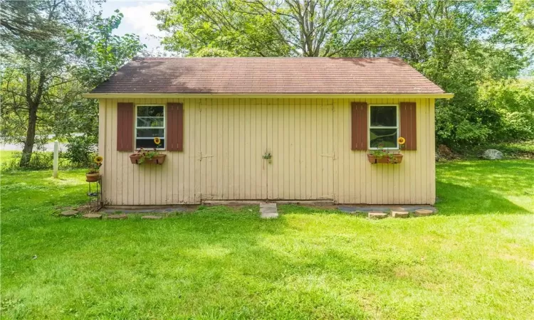 View of outdoor structure with a yard