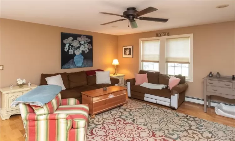 Living room with ceiling fan and light hardwood / wood-style floors