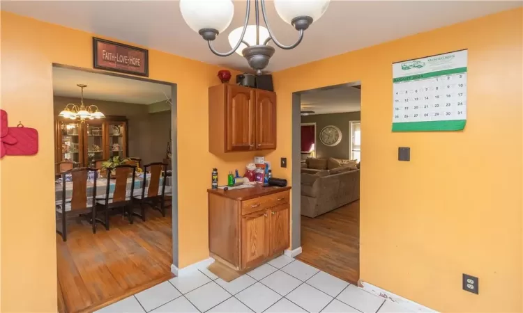 Kitchen with decorative light fixtures, light hardwood / wood-style floors, and an inviting chandelier