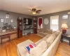 Living room with baseboard heating, light hardwood / wood-style flooring, and ceiling fan