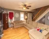 Living room featuring a baseboard heating unit, light hardwood / wood-style flooring, ceiling fan, and cooling unit