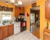 Kitchen featuring white dishwasher, light hardwood / wood-style floors, a notable chandelier, sink, and black electric range oven