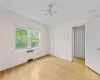 Empty room featuring crown molding, light hardwood / wood-style flooring, ceiling fan, and radiator heating unit