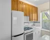 Kitchen with white appliances, tasteful backsplash, and sink