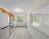 Kitchen with white appliances, light stone countertops, and light hardwood / wood-style floors