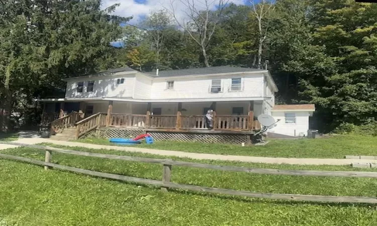 Back of house with a yard and covered porch