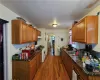 Kitchen with sink, dark stone counters, white gas stove, and dark hardwood / wood-style flooring