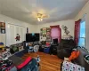 Living room featuring wood-type flooring, ornamental molding, and ceiling fan