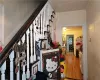 Staircase with hardwood / wood-style flooring and ornamental molding