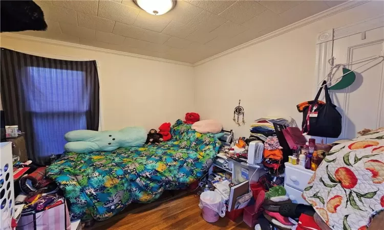 Bedroom featuring hardwood / wood-style flooring and ornamental molding