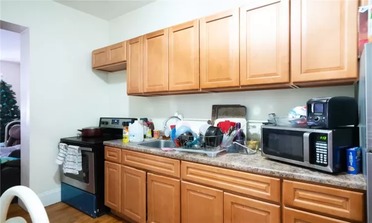 Kitchen with light hardwood / wood-style flooring, stainless steel appliances, and sink