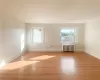 Empty room featuring radiator heating unit and light hardwood / wood-style flooring