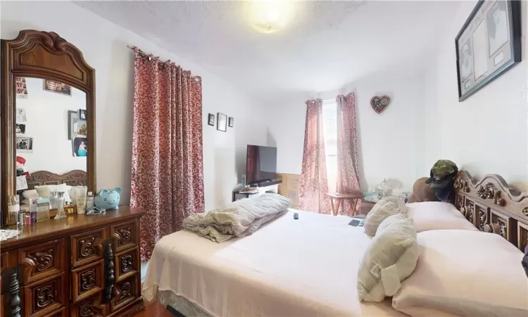 Bedroom 1 unit 1 with a textured ceiling