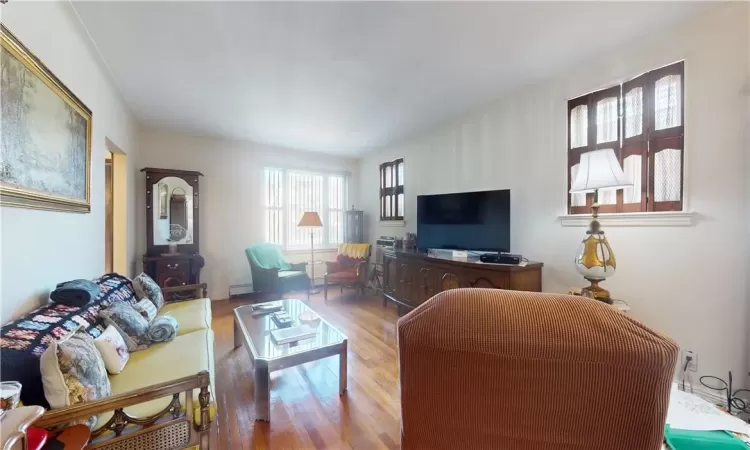 Living room with hardwood and a baseboard heating unit