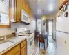 Kitchen featuring white appliances, decorative light fixtures, sink, light stone counters, and light tile patterned floors