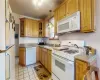 Kitchen featuring ceiling fan, pendant lighting, white appliances, sink, and light tile patterned floors