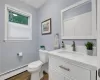 Bathroom with hardwood / wood-style flooring, vanity, toilet, and baseboard heating