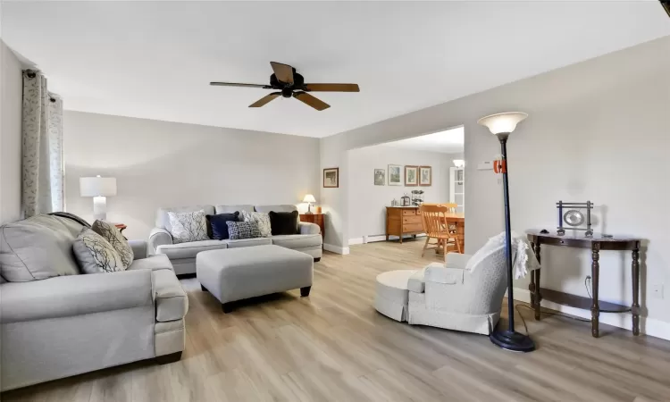 Living room with ceiling fan and light hardwood / wood-style floors