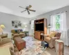 Living room with ceiling fan, a healthy amount of sunlight, a baseboard heating unit, and light hardwood / wood-style flooring