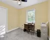 Carpeted home office featuring ceiling fan and a baseboard radiator