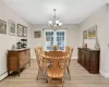 Dining area with light wood-type flooring, baseboard heating, and a chandelier