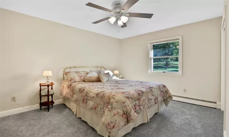 Bedroom featuring carpet flooring, a baseboard radiator, and ceiling fan