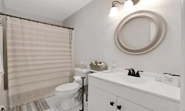 Bathroom with tile patterned flooring, vanity, and toilet