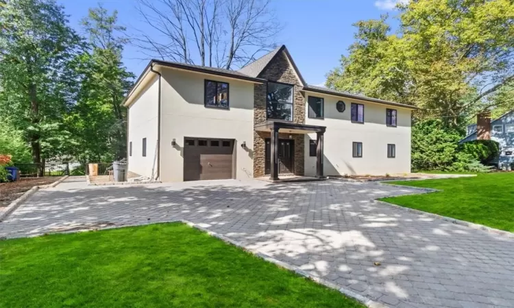 View of front of house featuring a garage and a front lawn