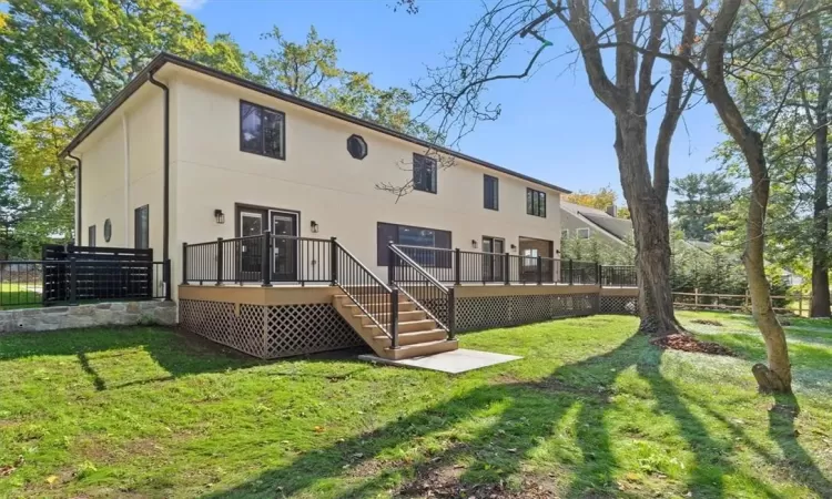 Rear view of property featuring a deck and a yard