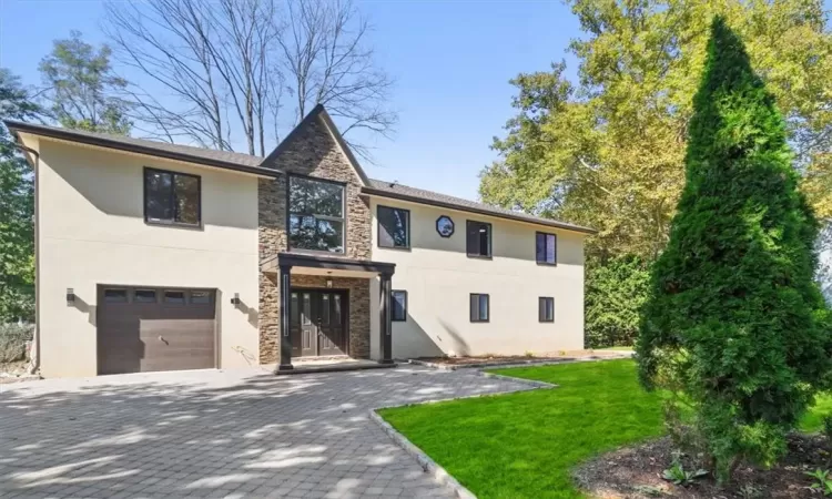 View of front of property with a front yard and a garage