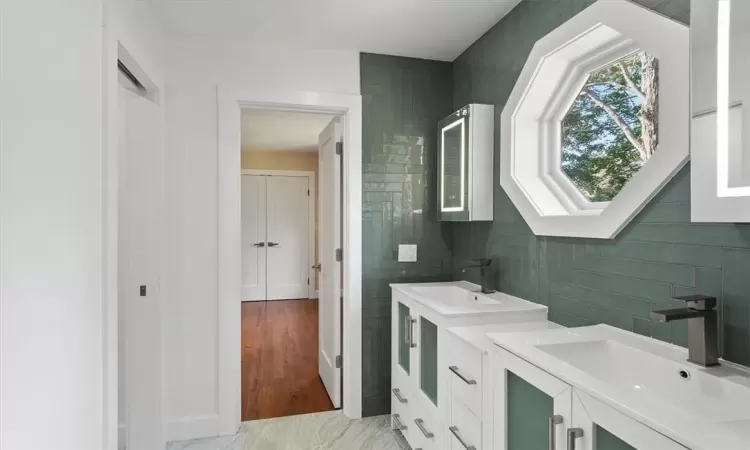 Jack and Jill bathroom with granite flooring and a privacy door for toilet and shower area