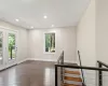 Spare room with a wealth of natural light and dark wood-type flooring