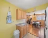 Kitchen featuring ceiling fan, baseboard heating, light hardwood / wood-style flooring, a wall mounted AC, and a textured ceiling