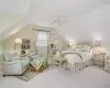 Carpeted bedroom with ceiling fan, a baseboard radiator, and lofted ceiling