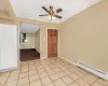 Tiled spare room featuring ceiling fan and a baseboard heating unit