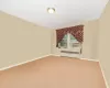 Spare room with radiator heating unit and carpet flooring