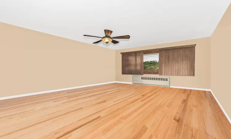 3rd floor living room w/ ceiling fan & hardwood floors