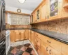 Kitchen with dark stone counters, black oven, and decorative backsplash