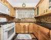 Kitchen featuring dark stone counters, white appliances, and tasteful backsplash