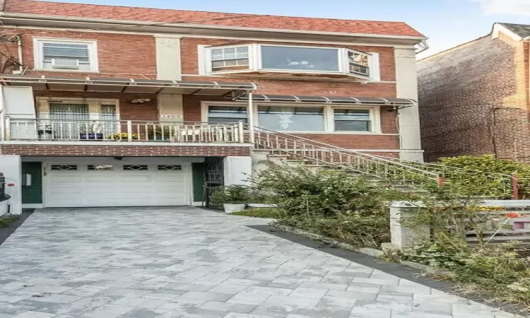 View of front of property featuring cooling unit and a garage