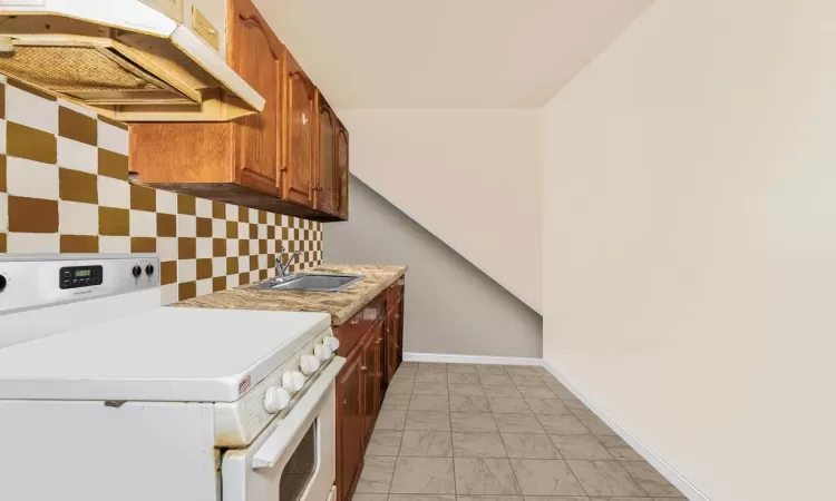 Kitchen with white stove and sink