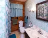 Upstairs Bathroom with vanity, wood walls, and toilet