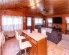 Kitchen featuring wood walls, ceiling fan, a kitchen island, wood ceiling, and lofted ceiling