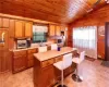 Kitchen with wood ceiling, sink, wooden walls, a center island, and vaulted ceiling