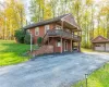 View of front of property with an outbuilding, a wooden deck, a front lawn, and a garage