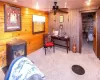 Sitting room with wooden walls, ceiling fan, and carpet flooring