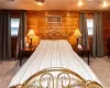 Carpeted bedroom featuring wooden walls and wood ceiling